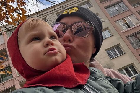 Matka dojčí dieťa v prírode počas fotografovania